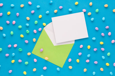 High angle view of multi colored paper against blue background