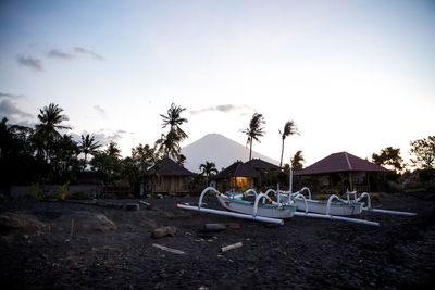 Boats on beach against sky during sunset