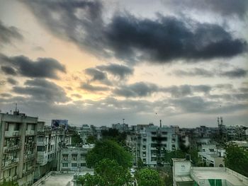 View of cityscape against cloudy sky