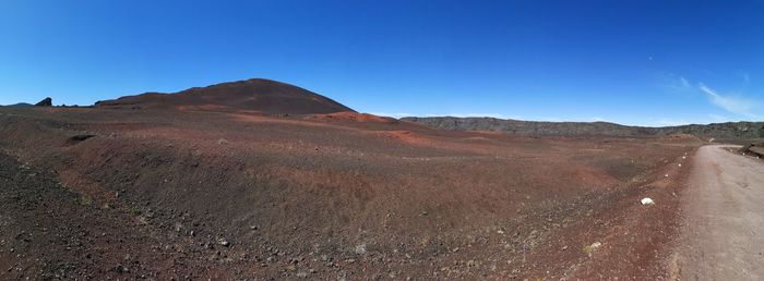 Scenic view of arid landscape against clear blue sky