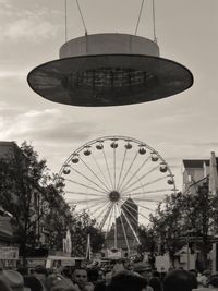 People in amusement park against sky