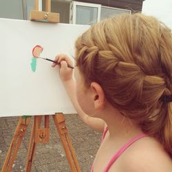 Close-up of girl painting on canvas fabric