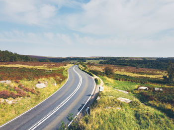 Empty road along countryside landscape