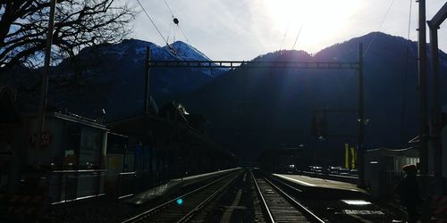 Railroad tracks in city against sky