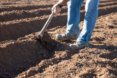 Low section of man working in mud on field