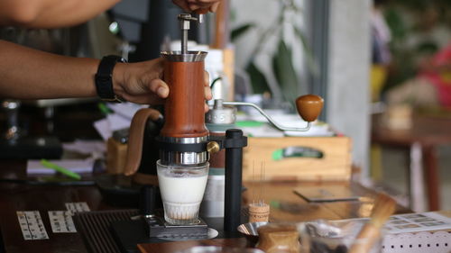 Close-up of hand pouring coffee in cup