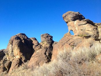 Low angle view of rocks against blue sky