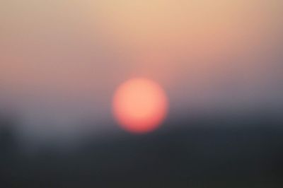Defocused image of sun in sky during sunset