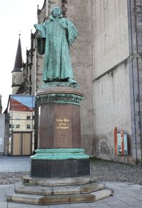 Statue against historic building in city