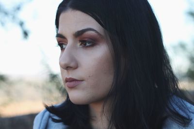 Close-up portrait of a young woman looking away