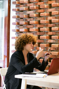 Young woman using laptop while sitting in cafe