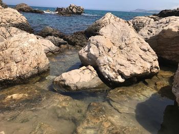 Rocks by sea against sky