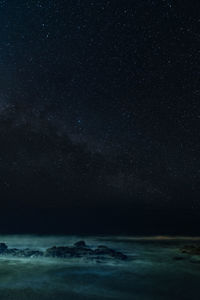 Long exposure of scenic view of sea against starry sky at night