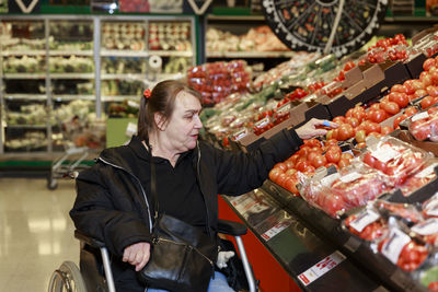 Woman on wheelchair doing shopping