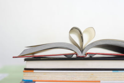 Close-up of open book on table against white background