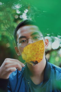 Close-up portrait of boy holding leaf