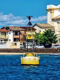 Sailboats in sea against buildings in city