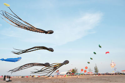 Low angle view of kites flying against sky