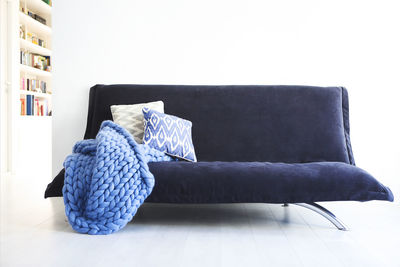 Hooded chair on table against white wall at home