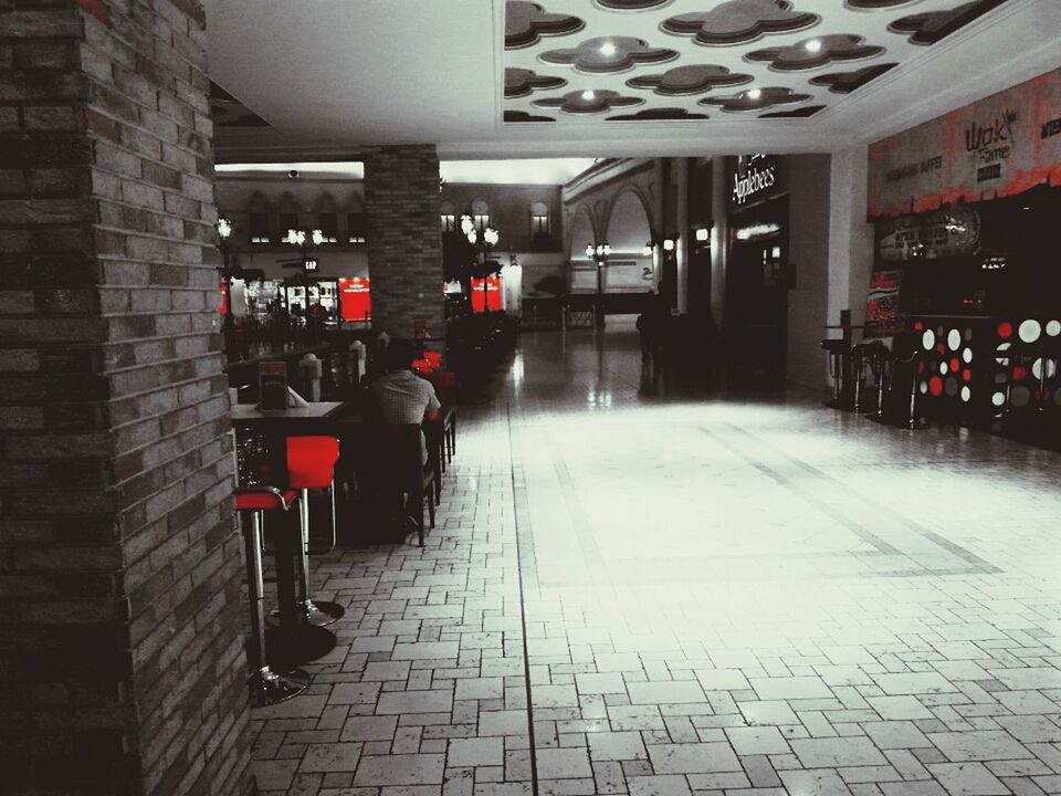 indoors, illuminated, architecture, built structure, chair, empty, absence, lighting equipment, flooring, tiled floor, in a row, the way forward, incidental people, restaurant, seat, corridor, city, table, building exterior, building