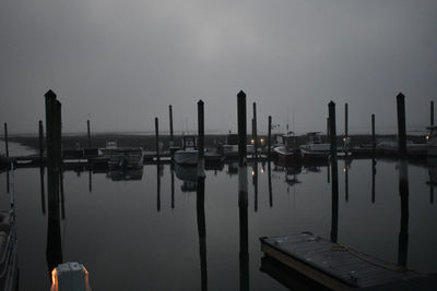 Sailboats moored in sea against sky