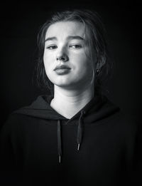 Portrait of a beautiful young woman over black background