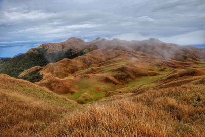 Scenic view of field and mountains against sky