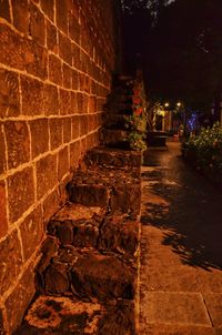 Illuminated walkway in city at night