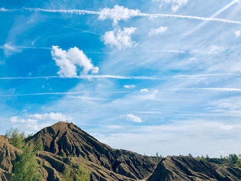 Low angle view of clouds over mountain against sky