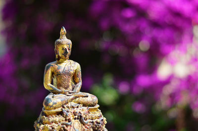 Close-up of buddha statue against tree