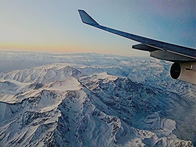 snow, airplane, aircraft wing, winter, air vehicle, mountain, cold temperature, landscape, transportation, flying, snowcapped mountain, scenics, mode of transport, beauty in nature, season, aerial view, sky, tranquil scene, cropped, part of