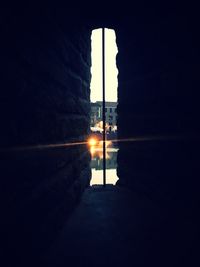 Silhouette buildings by street against sky in city