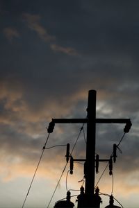 Low angle view of power lines against cloudy sky