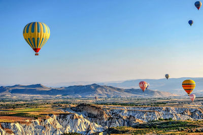 Hot air balloons flying over landscape