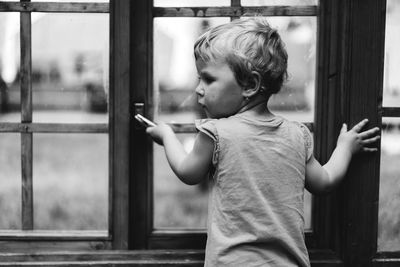 Side view of boy looking through window