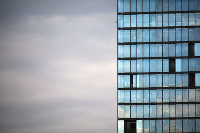 Low angle view of glass building against sky