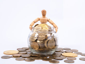 Close-up of coins in container against white background