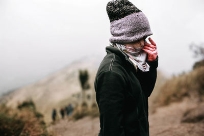 Midsection of person wearing hat standing in snow