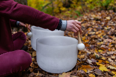 Midsection of man playing singing bowl outdoors