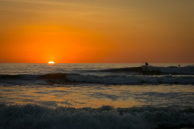 Scenic view of sea against orange sky