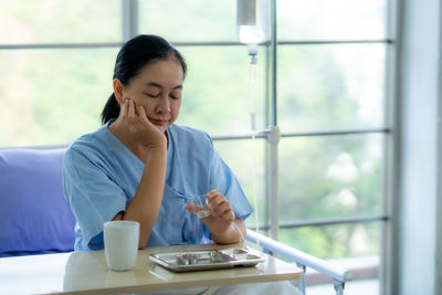 Young woman using mobile phone while sitting in cafe