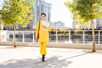 Full length of young woman standing in city