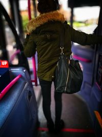 Rear view of woman standing on car