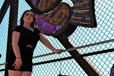 Low angle view of woman standing against wall