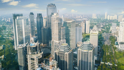 Aerial view of buildings in city against sky