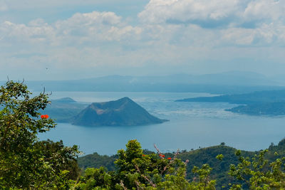 Scenic view of sea and mountains against sky