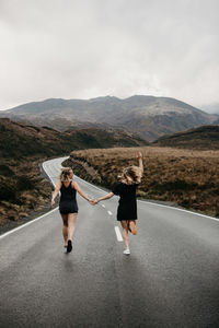 People on road against mountain range