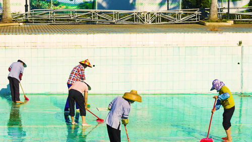 People cleaning swimming pool