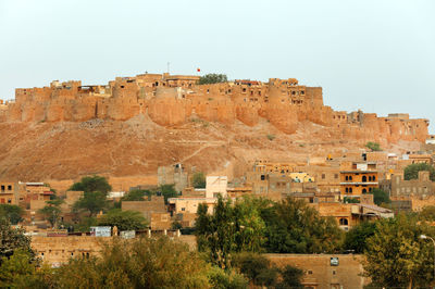 Buildings in town against clear sky