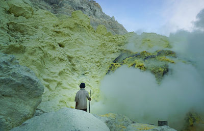 Rear view of man standing on rock